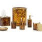 The Benton Tortoise Bath Collection by Pigeon & Poodle features tortoiseshell-patterned accessories, including a tissue box cover, waste bin, toothbrush holder, soap dispenser, tumbler, dish, and lidded container for an elegant bath.