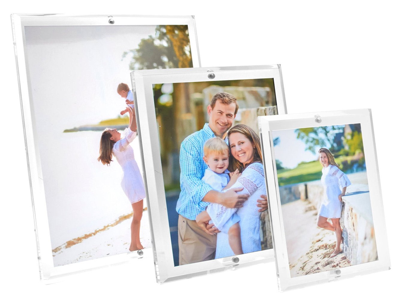 The Clear Beveled Frame Collection by Tara Wilson Designs displays family photos and features built-in magnets for easy photo changes. The lucite frames have beveled faces, shown here with images of a family, couple with child, and woman on a beach.