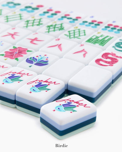 The Oh My Mahjong Tile Collection from Oh My Mahjong features hand-painted tiles with vibrant designs like flowers and symbols, topped off by a prominent joker tile showcasing a bird motif to enhance your gaming experience.