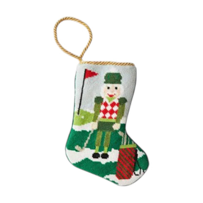 The Bauble Stockings Christmas Birdie Nutcracker Needle Point Stocking features a golf-loving nutcracker design and gold hanging loop—festive holiday decor for any golf enthusiast.