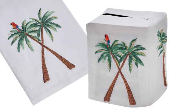 Two images showing tropical-themed fabric patterns; on the left, a close-up of a Haute Home King Palm Collection linen palm tree that is hand embroidered with a parrot, and on the right, a tissue box cover with Haute Home King Palm Collection.