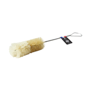The Be Home Bistro Flute Cleaning Brush features beige bristles, a twisted metal handle with a looped end for easy use, and a black tag near the handle—perfect for cleaning glassware.