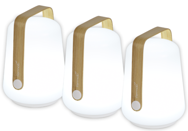 The Bamboo Balad Lamp set of 3 by Fermob features modern white lamps with wooden handles, arranged side by side, highlighting stylish portable lighting ideal for indoor or outdoor use.