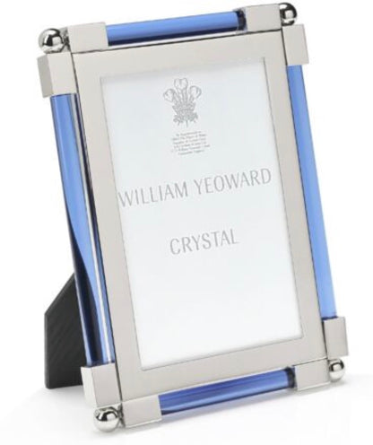 The Light Blue Classic Frame Collection by William Yeoward Crystal features a rectangular, nickel-plated photo frame with silver metal edges and blue glass accents; this classic item may carry a Proposition 65 warning.