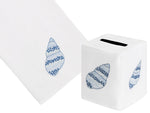 The Haute Home Speckled Conch Bath Collection in Blue features a white Italian linen tissue box cover and hand towel, each beautifully hand-embroidered with a blue seashell design.