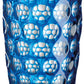 The Lente Acrylic Dinnerware Collection by Mario Luca Giusti features a blue tumbler with raised circular bubbles, perfect for outdoor entertaining.