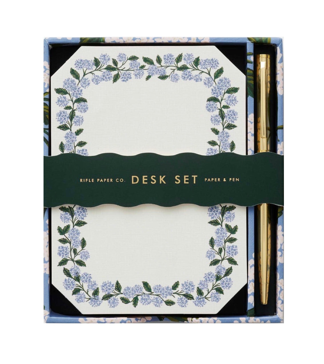 The Blue Hydrangea Desk Accessory Collection by Riffle Paper Co. includes a floral-bordered notepad and gold pen, making it the perfect addition to any workspace.