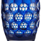 The Mario Luca Giusti Lente Acrylic Dinnerware Collection features a blue tumbler with raised circular indents—ideal for outdoor entertaining.