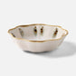 The Amoria Dinnerware Collection by Blue Pheasant features a scalloped ceramic bowl with a white reactive glaze, brown-edged rim, and vertical brown and green accents, radiating vintage-inspired elegance on a white background.