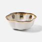 The Amoria Dinnerware Collection by Blue Pheasant features a ceramic bowl with a wavy rim, cream-colored reactive glaze, and brown-blue accents near the edge, offering vintage-inspired elegance displayed on a plain white background.