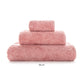 A stack of three blush pink towels from the Egoist Bath Collection by Graccioza, crafted from luxurious Egyptian cotton in varying sizes and arranged largest to smallest, sits on a white background.
