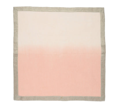 The Kim Seybert Dip Dye Napkin Set by Kim Seybert features a square cloth with an autumnal gradient design, transitioning from light pink at the bottom to beige at the top, bordered by a gray edge.
