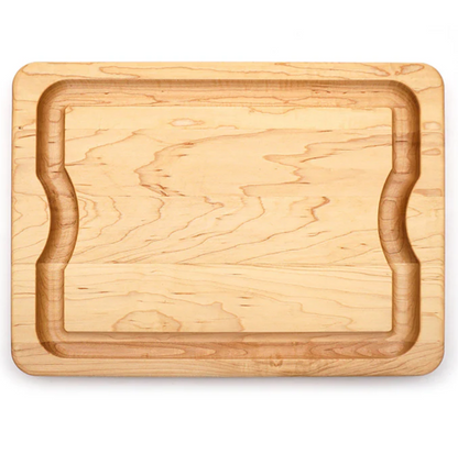 The J.K. Adams Maple BBQ Cutting Board features a rectangular shape, recessed groove, and indented sides for grip, shown against a white background.