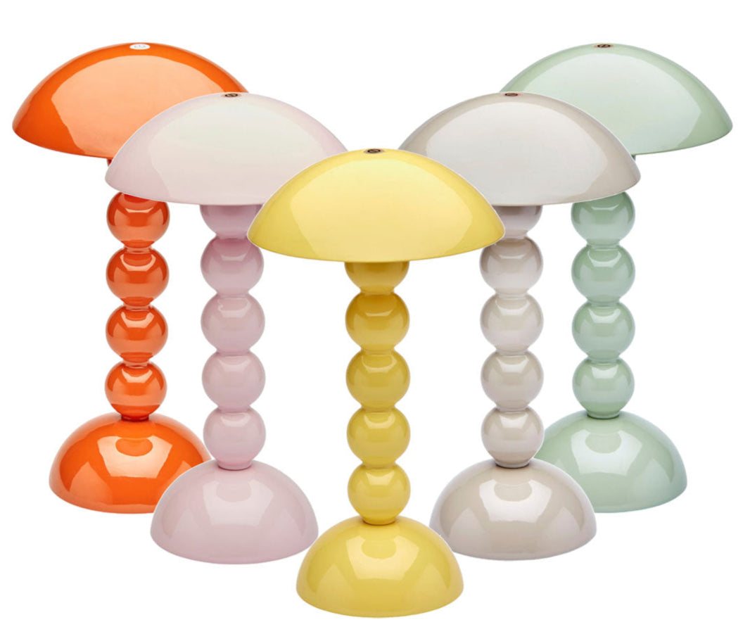 Five Addison Ross Bobbin LED Cordless Lamps, featuring rounded tops and bubble-like stems in pastel and bright colors, provide portable lighting with adjustable levels. All are arranged together against a white background.