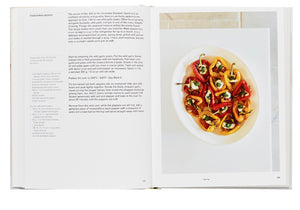 An open Phaidon Home Farm Cooking cookbook from the Phaidon recipe collection displaying a recipe on the left page and a colorful plated dish on the right, likely the completed recipe from the cookbook.