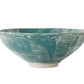 The Geode Bowl Collection by Paul Schneider Ceramics features wide-rimmed bowls with turquoise glaze and white marbled swirls, offering elegant uniqueness against a plain background.