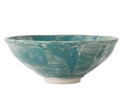 The Geode Bowl Collection by Paul Schneider Ceramics features wide-rimmed bowls with turquoise glaze and white marbled swirls, offering elegant uniqueness against a plain background.