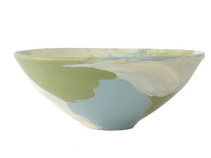 The Geode Bowl Collection by Paul Schneider Ceramics features a ceramic bowl with a glossy finish and a soft green, blue, and cream marbled swirl pattern for a colorful touch.