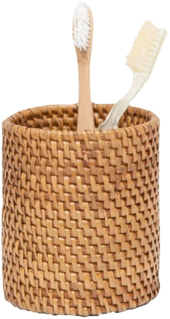 The Dalton Bath Collection by Pigeon & Poodle features a finely crafted woven cylindrical holder, colored with organic dyes, containing two toothbrushes—one wooden and one white.