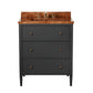 The Conrad Vanity Collection by Made Goods features a floating design with a matte black base, three soft-close drawers, gold knobs, and a glossy wood countertop with an integrated sink and brass faucet.