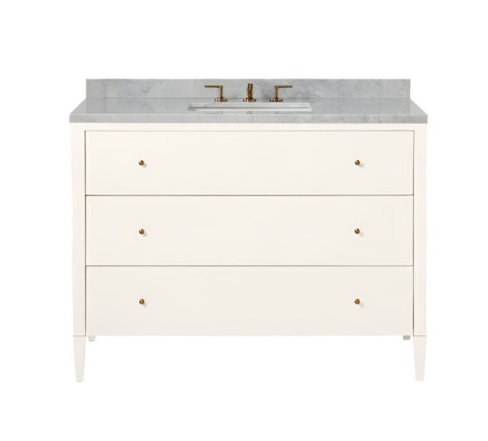 The Conrad Vanity Collection by Made Goods features a white floating bathroom vanity with soft-close drawers, marble countertop, rectangular sink, and brass faucet fixtures.