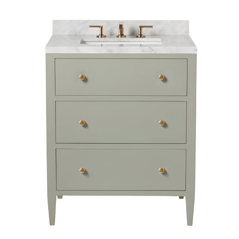 The Jarin Vanity Collection by Made Goods features a light gray freestanding vanity with three drawers, brass hardware, a white marble countertop, and a brass faucet.