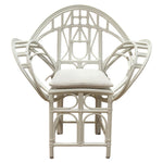 The Butterfly Chair by McGuire Furniture features white rattan with an intricate geometric backrest, armrests, and a light seat cushion—a design inspired by Edward Tuttle’s refined aesthetic.