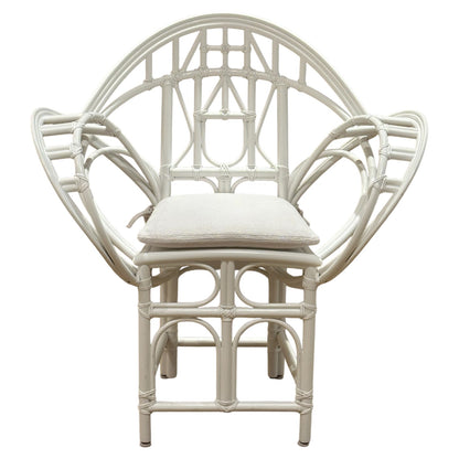 The Butterfly Chair by McGuire Furniture features white rattan with an intricate geometric backrest, armrests, and a light seat cushion—a design inspired by Edward Tuttle’s refined aesthetic.