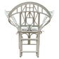 The Butterfly Chair by McGuire Furniture features a white rattan frame with an intricate, geometric backrest inspired by Edward Tuttle and a tied-on seat cushion, shown from the back.