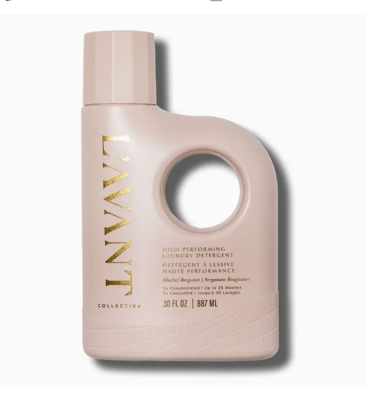 A pale pink bottle of L’Avant Collective Blushed Bergamot laundry detergent with a large circular handle, gold lettering, and text indicating it provides up to 35 washes.