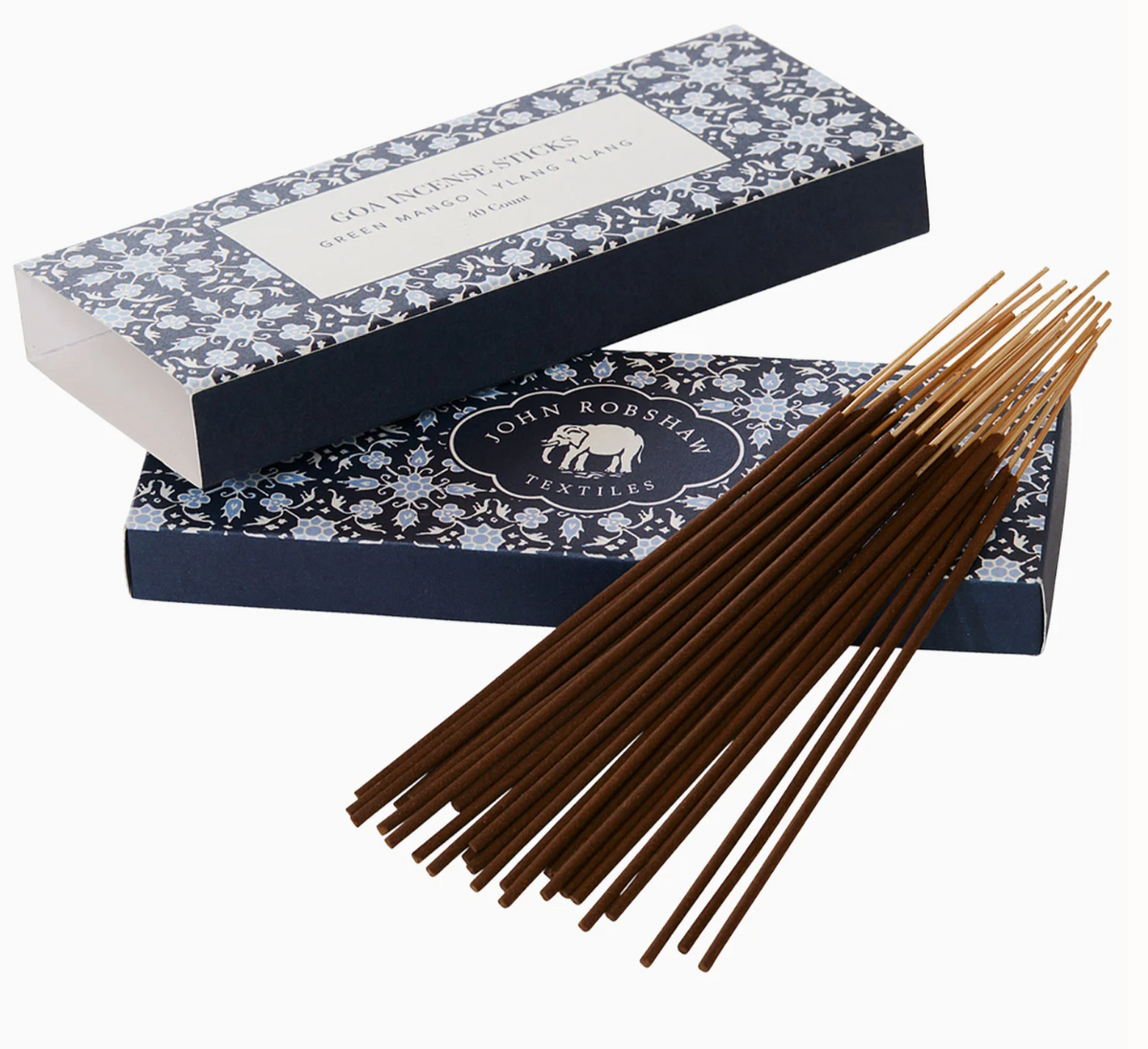 A bundle of ylang-ylang incense sticks from the Goa Candle & Incense Collection rests in front of two rectangular boxes decorated with a blue and white floral pattern.