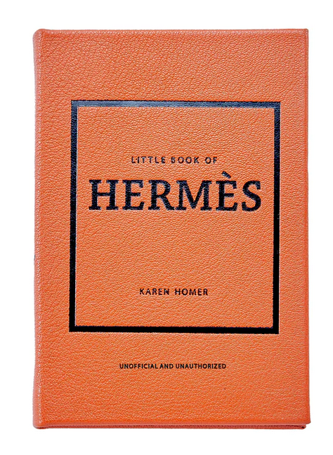 The orange book, titled "Little Book of Hermes" by fashion historian Karen Homer, is an unofficial and unauthorized guide to the luxurious world of Hermès accessories, brought to you by Graphic Image.