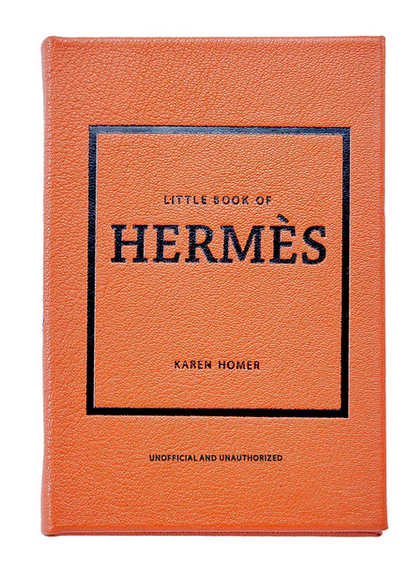 The orange book, titled "Little Book of Hermes" by fashion historian Karen Homer, is an unofficial and unauthorized guide to the luxurious world of Hermès accessories, brought to you by Graphic Image.