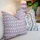 Two Harwick Stripe Olive and Plum Pillows by Hive Custom Pillows rest on a light-colored sofa, with a lamp and leafy plant visible in the background.
