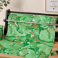 A roll of Caspari Marbled Green Roll Wrap made from heavyweight paper sits on a dispenser atop a wooden table, surrounded by gift wrapping supplies and a framed sign in the background. Printed with earth-friendly inks, this Caspari wrap is perfect for thoughtful and sustainable presentations.