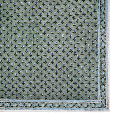 Rectangular area rug with a green background, intricate florals, and a decorative border—ideal for pairing with SLOANE BY HAND’s Alwar Table Linen Collection to elevate your dining space.