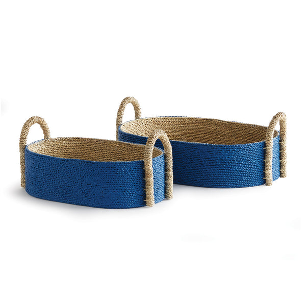 The Napa Home & Garden Tiana Blue Seagrass Short Oval Basket Collection features two handwoven baskets with blue exteriors and natural handles, elegantly displayed on a white background.