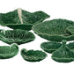 The HIVE Cabbage Leaf Green Collection is a ceramic handmade serveware set from Portugal, featuring leaf-shaped dishes, bowls, a serving spoon, and a divided dish.