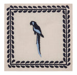 The Caica Cocktail Napkin Set by Johanna Ortiz features a blue and black parrot at the center, framed by black leaf patterns on beige—an elegant way to add tropical chic to your decor or stylishly serve drinks.