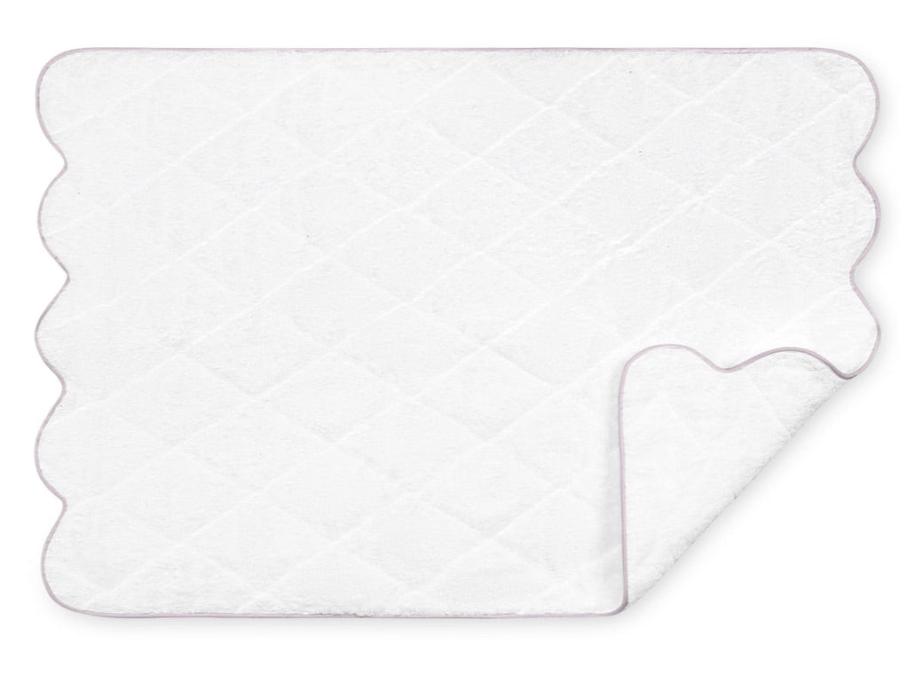 The Matouk Cairo Scallop Bath Collection features a white quilted bath mat with scalloped edges, beautifully complementing our long-staple cotton terry towels.