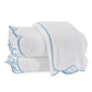 Part of the Matouk Cairo Scallop Bath Collection, these three white terry towels with light blue borders are neatly folded, showcasing the softness of long-staple cotton.