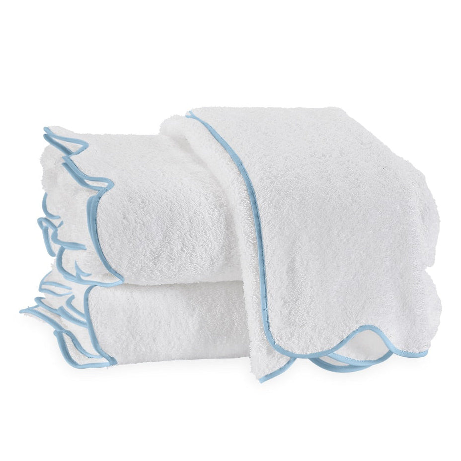 Part of the Matouk Cairo Scallop Bath Collection, these three white terry towels with light blue borders are neatly folded, showcasing the softness of long-staple cotton.