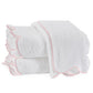 Three terry towels from the Matouk Cairo Scallop Bath Collection, with pink-trimmed edges, are neatly folded and arranged against a pristine white background.