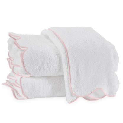 Three neatly folded Cairo Scallop Bath Collection towels by Matouk, crafted from long-staple cotton with pink scalloped trim, are stacked on top of each other against a plain white background.