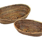 The Calaisio Oval Bread Basket Collection features two empty, eco-crafted oval baskets—one large, one small—expertly handwoven and placed side by side on a white background, perfect for serving freshly baked bread.