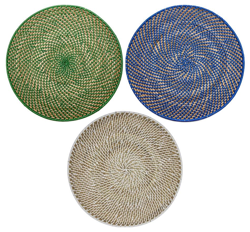 The Deborah Rhodes Calypso Rattan Placemat Set features three hand-woven round placemats in green, blue, and beige with a spiral design, arranged in a triangle—ideal for versatile indoor or outdoor use.