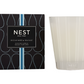 A Nest Ocean Mist & Sea Salt Candle from the Candle Collection sits by its stylish black and blue box, filling the room with refreshing ocean mist and sea salt fragrance.