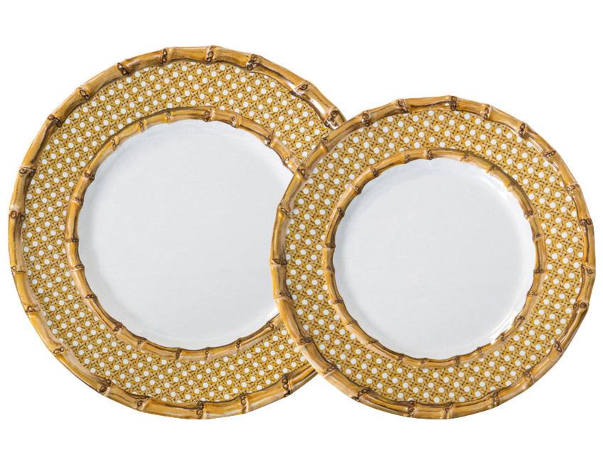 Two round plates from the Juliska Bamboo Caning Melamine Dinnerware Collection, featuring white centers and gold bamboo lattice rims, overlap each other. Made from shatterproof melamine.