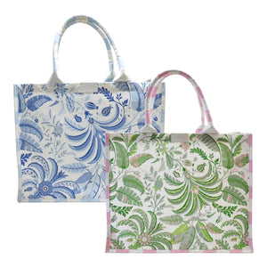 Two rectangular Addison Ross Palm Beach Tote Bags with handles: one features a blue and white floral design, the other a green and pink botanical pattern.