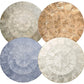 Four Capiz Placemats by Kim Seybert, featuring textured, segmented patterns in silver, gold, blue, and white, create a stylish table backdrop when arranged in a two-by-two grid.
